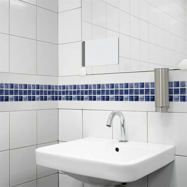 Frise de mosaïque bleu marine au-dessus d'un lavabo suspendu, sur un carrelage blanc 15