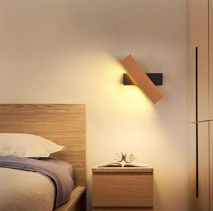 Applique pivotante en bois et support noir allumée au-dessus d'une table de chevet, dans une chambre au lit en bois. 6