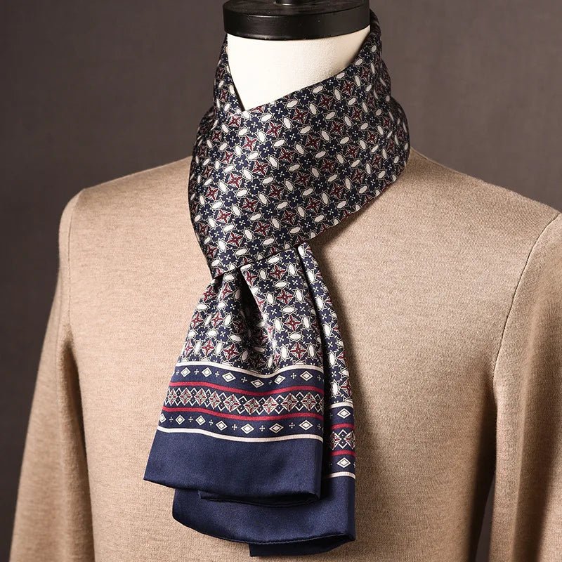 Foulard en soie bleu marine à motif d'étoiles et d'ovales, noué sur un mannequin en pull beige, bordure à losanges rouges. 21