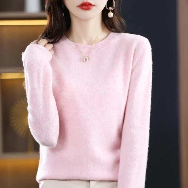 Pull à col rond rose pâle porté par une femme, une main dans les cheveux 23