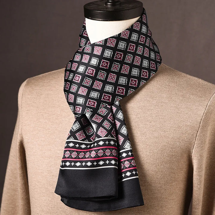 Foulard en soie noir à carrés roses et blancs, bordure noire à motifs géométriques roses, sur mannequin avec pull beige. 15