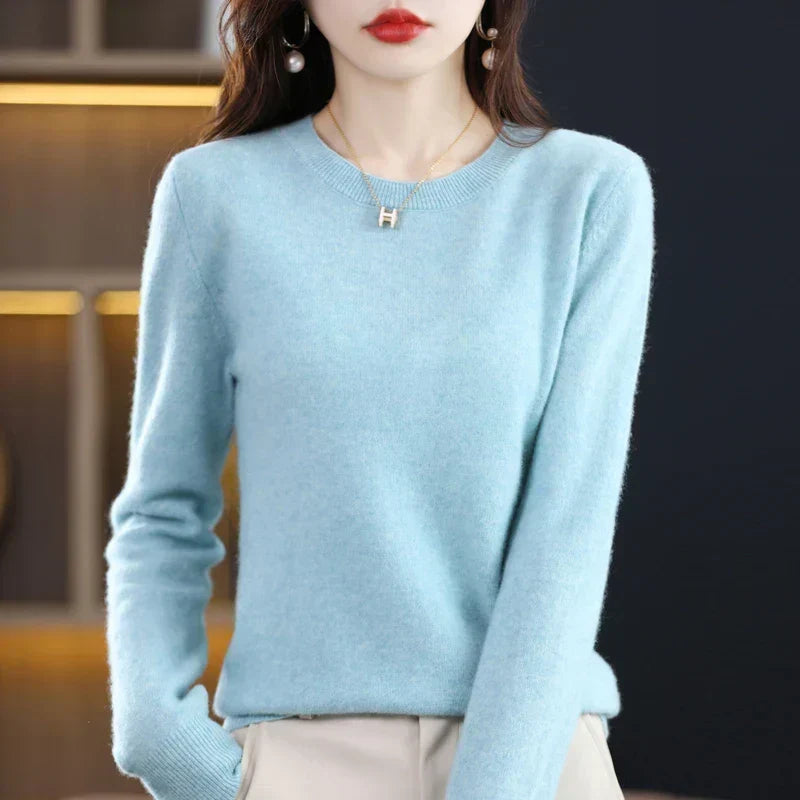 Pull col rond bleu ciel porté par une femme, mains dans les poches d'un pantalon beige 11