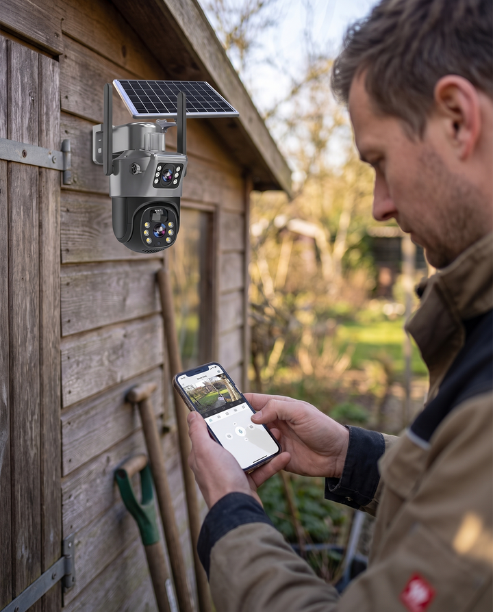 Homme consultant l'image de la caméra sur son smartphone, la caméra solaire étant fixée sur le mur d'une cabane de jardin. 4