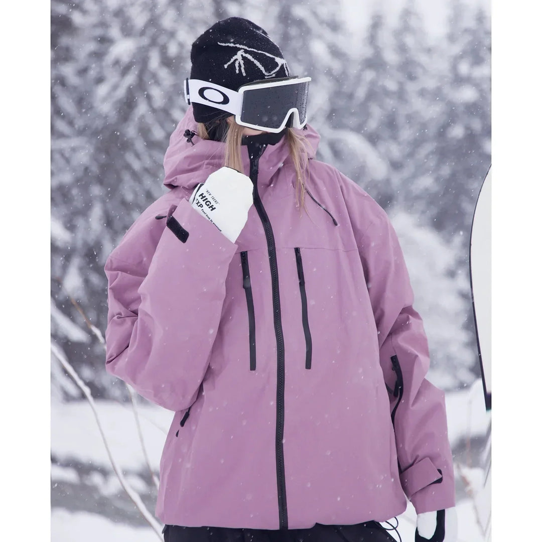 Gros plan de trois quarts sur la veste rose mauve, poches zippées sur la poitrine et capuche relevée, sous les flocons. 4