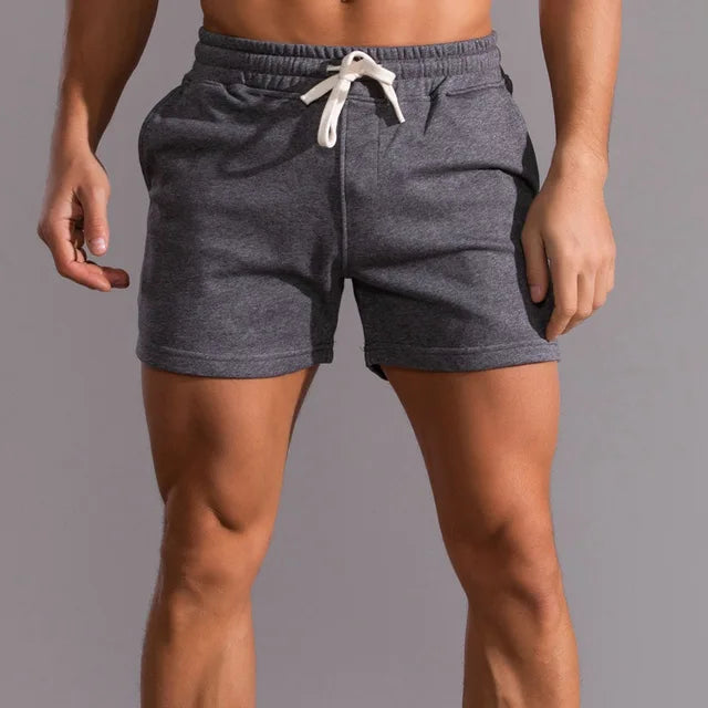 Short gris foncé porté par un homme, vu de face, avec cordon blanc noué à la taille et poches latérales. 3