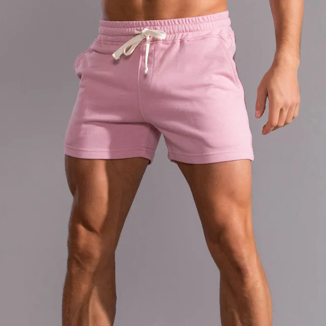 Short rose porté par un homme, vu de face, avec ceinture élastique et cordon de serrage blanc noué à la taille. 6