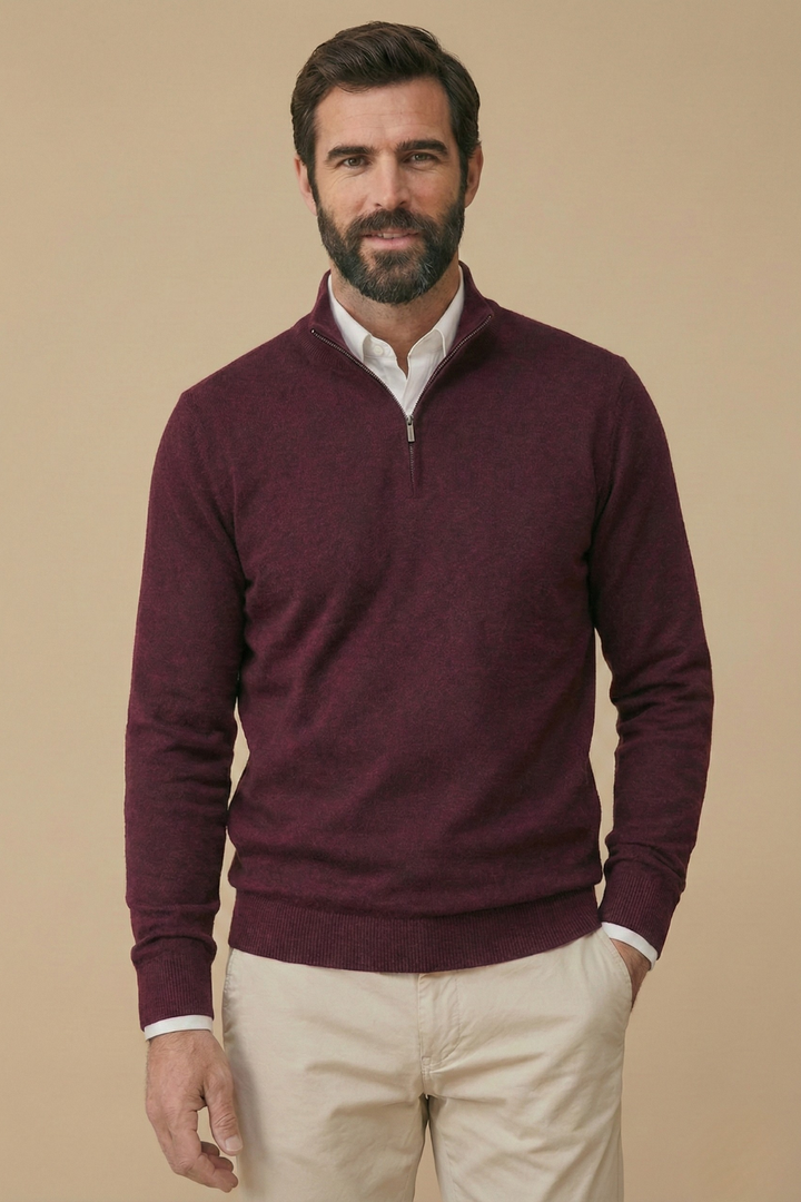 Homme souriant en pull bordeaux à demi-zip, chemise blanche dessous, pantalon beige 4