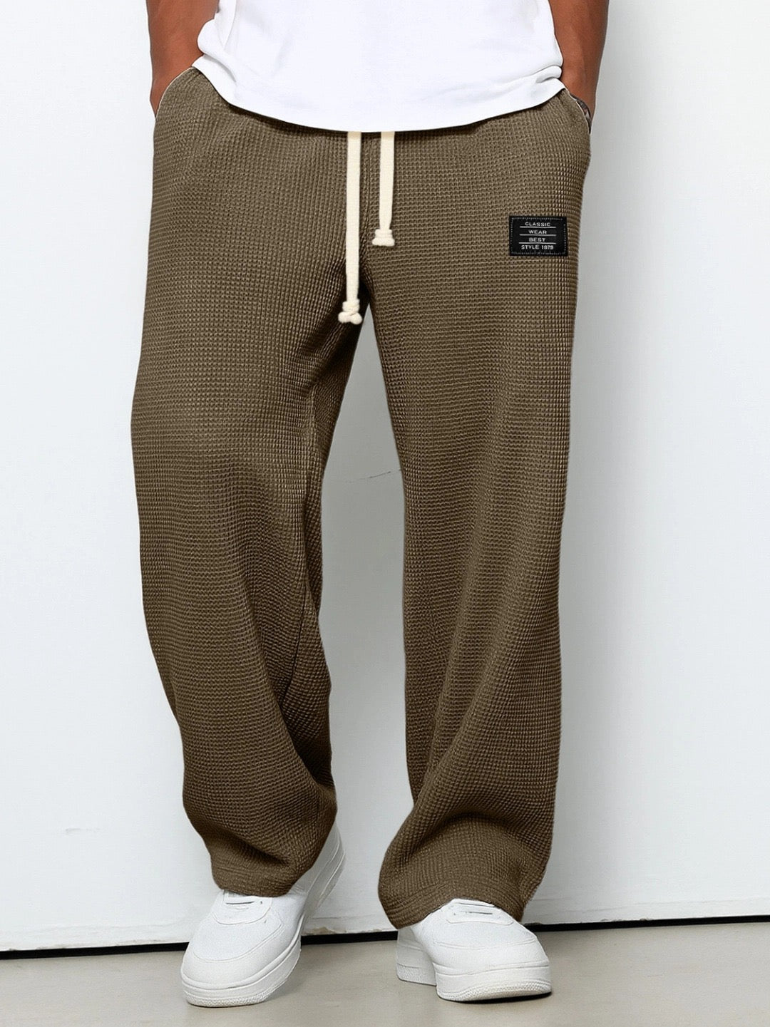 Version marron taupe du pantalon large en maille gaufrée, cordon beige noué, porté avec un t-shirt blanc et des baskets blanches. 5