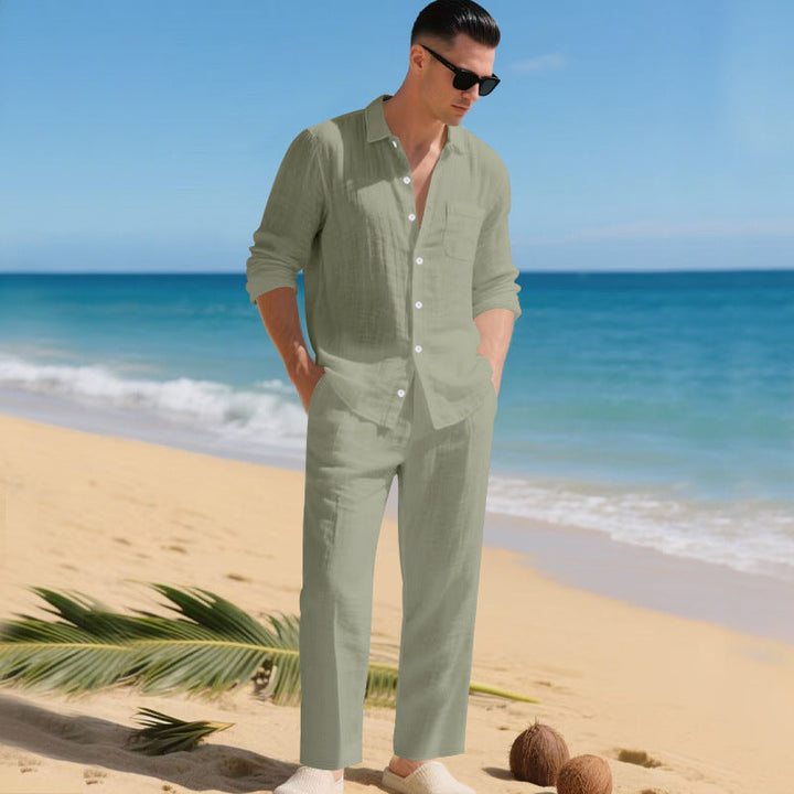 Modèle masculin sur le sable avec noix de coco, portant la chemise et le pantalon assortis en vert sauge. 7