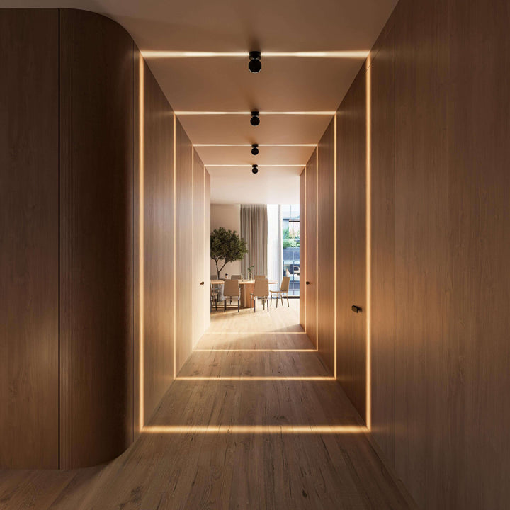 Perspective frontale d'un couloir en bois avec quatre appliques noires créant des bandes de lumière sur les murs et le parquet. 16