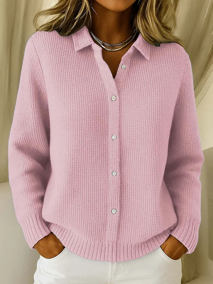 Même pull en maille texturée coloris rose pâle, porté avec un pantalon blanc, col rabattu et boutonnage devant. 2