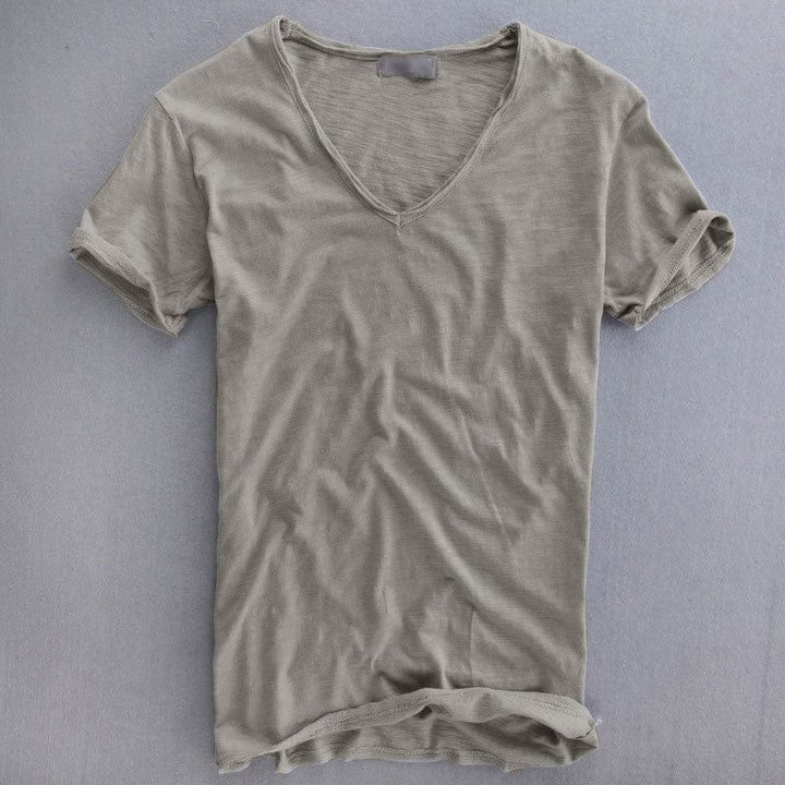 Vue de face à plat du t-shirt col en V gris clair, manches courtes retroussées et tissu légèrement texturé. 1