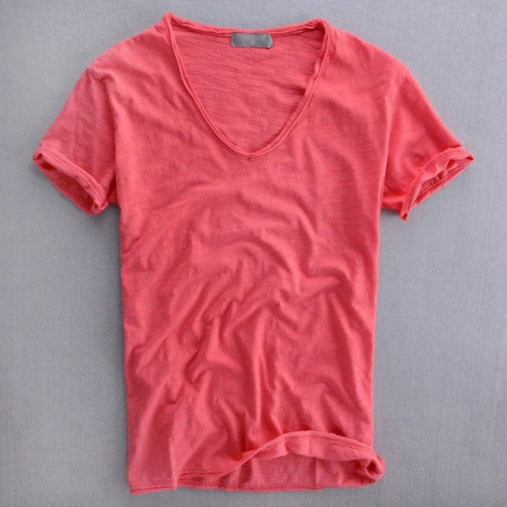 Vue de face à plat du t-shirt col en V rose corail, manches courtes retroussées et finitions brutes au col. 3