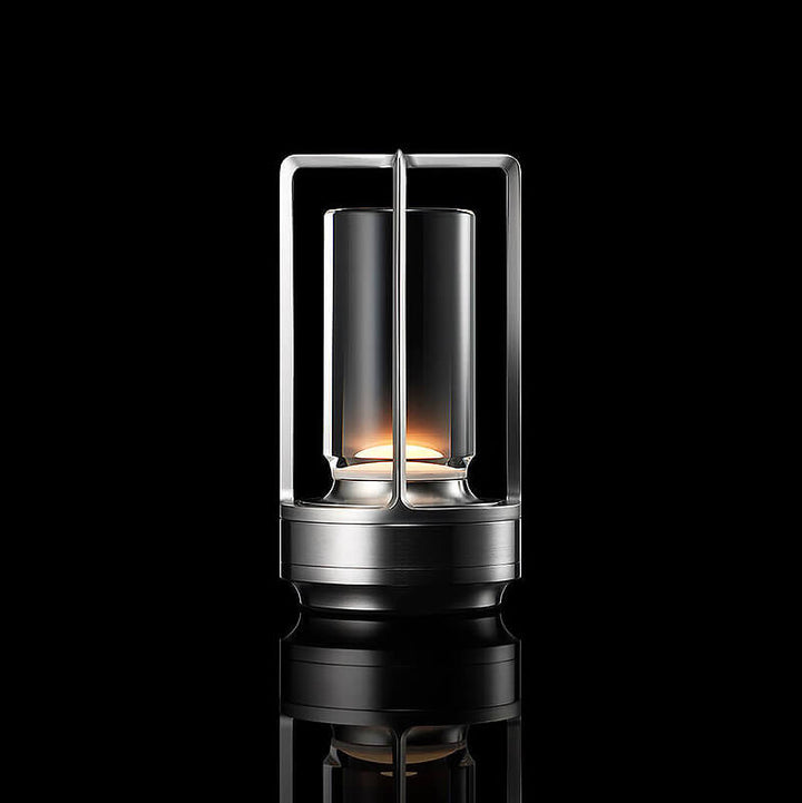 Lampe cylindrique à cadre ouvert et base argentés, allumée sur fond noir avec reflet au sol. 10