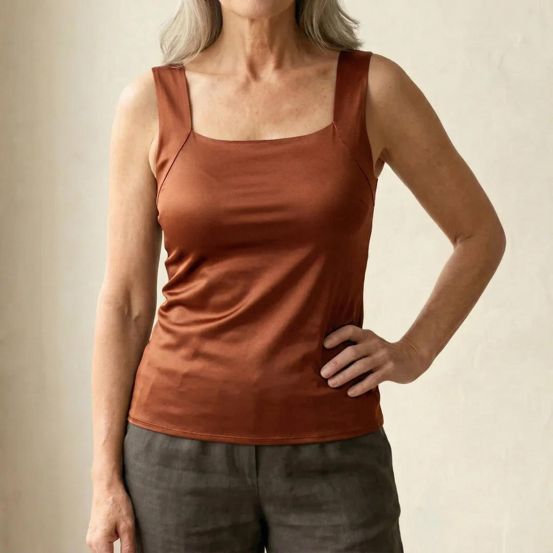 Débardeur couleur rouille à l'aspect satiné, porté avec un pantalon gris foncé, vu de face, main sur la hanche. 13