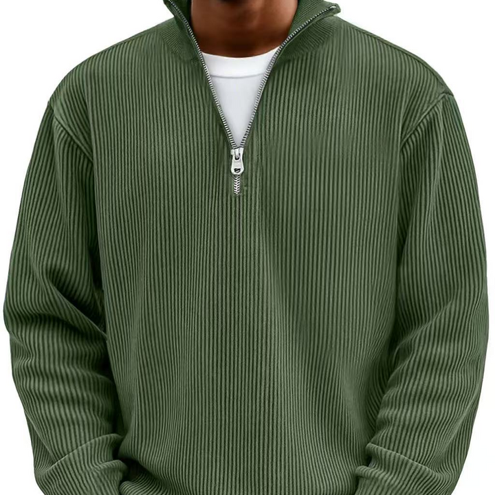 Pull côtelé vert kaki à col montant et demi-zip, porté de face sur un t-shirt blanc. 12