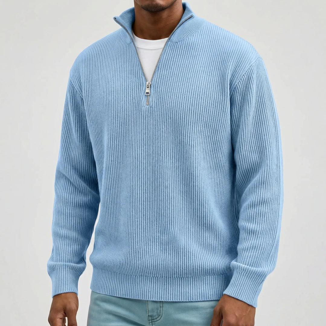Buste d'un mannequin portant le pull côtelé bleu clair à col montant zippé sur un t-shirt blanc, fond gris. 3
