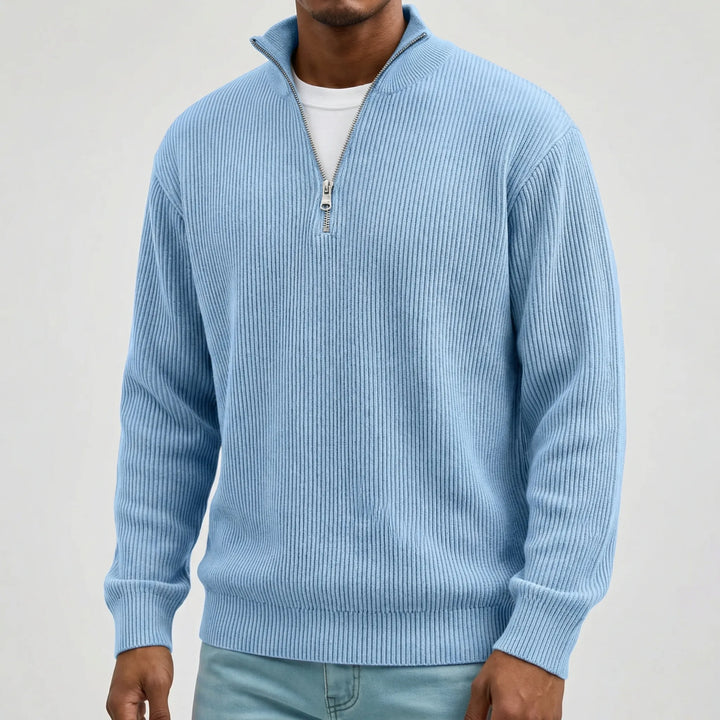 Buste d'un mannequin portant le pull côtelé bleu clair à col montant zippé sur un t-shirt blanc, fond gris. 3