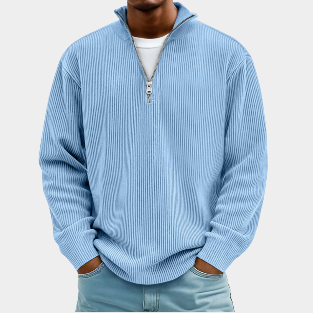 Pull côtelé bleu clair à demi-zip porté de face sur un t-shirt blanc, mains dans les poches d'un jean bleu. 5