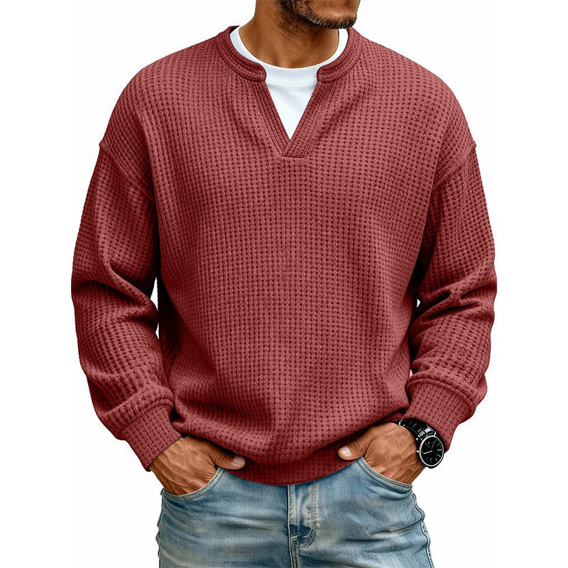 Pull gaufré rouge brique porté par un homme sur t-shirt blanc, mains dans les poches de son jean. 10