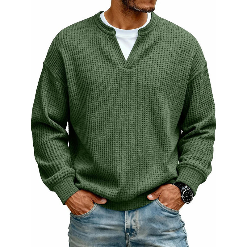 Pull gaufré vert foncé porté par un homme sur t-shirt blanc, mains dans les poches de son jean. 12