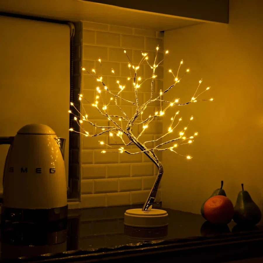 Lampe arbre allumée sur un plan de travail de cuisine, près d'une bouilloire crème et de fruits 5