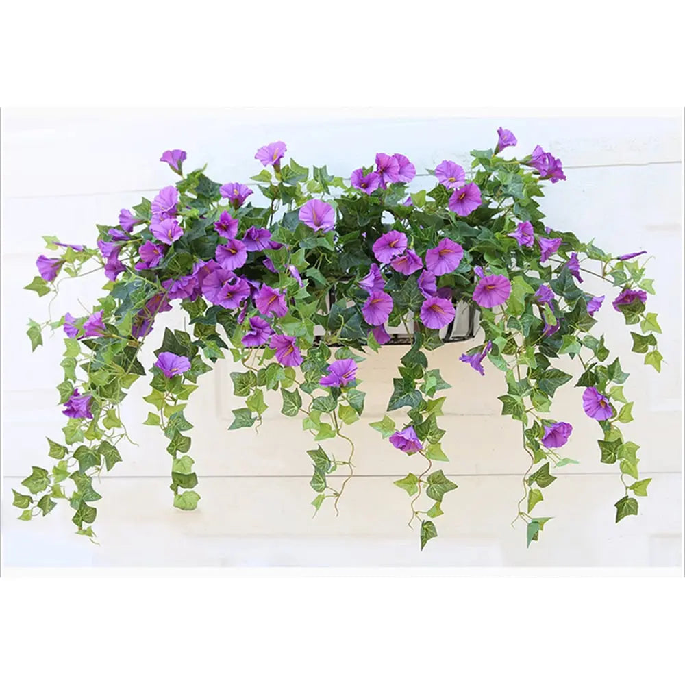Jardinière murale garnie de fleurs artificielles violettes et de longues tiges de lierre retombantes devant un mur blanc. 6