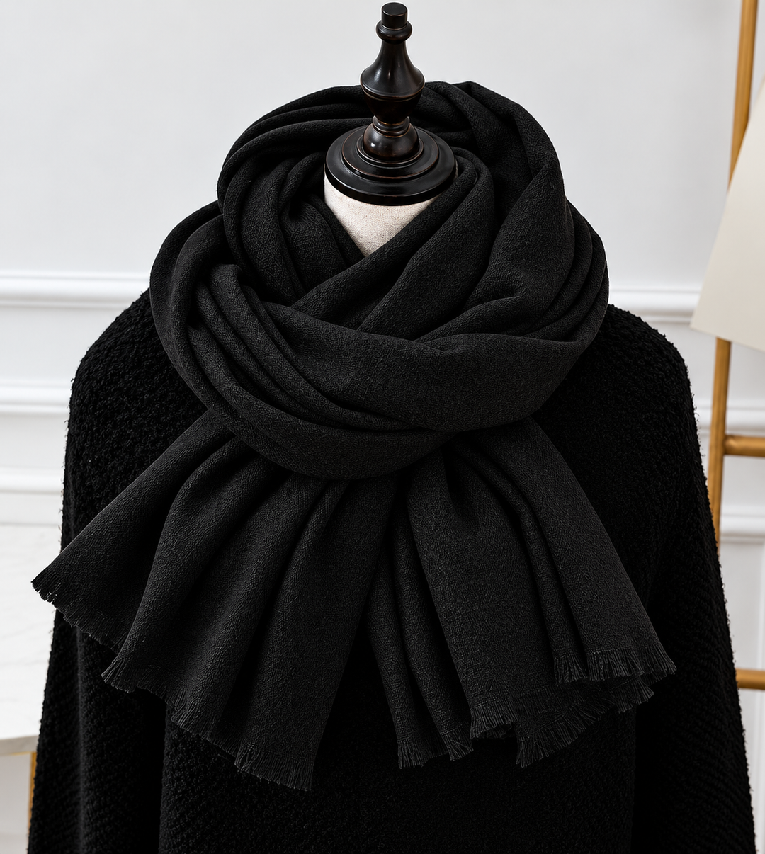 Écharpe noire à franges fines, drapée en volutes sur un mannequin portant un pull noir 3