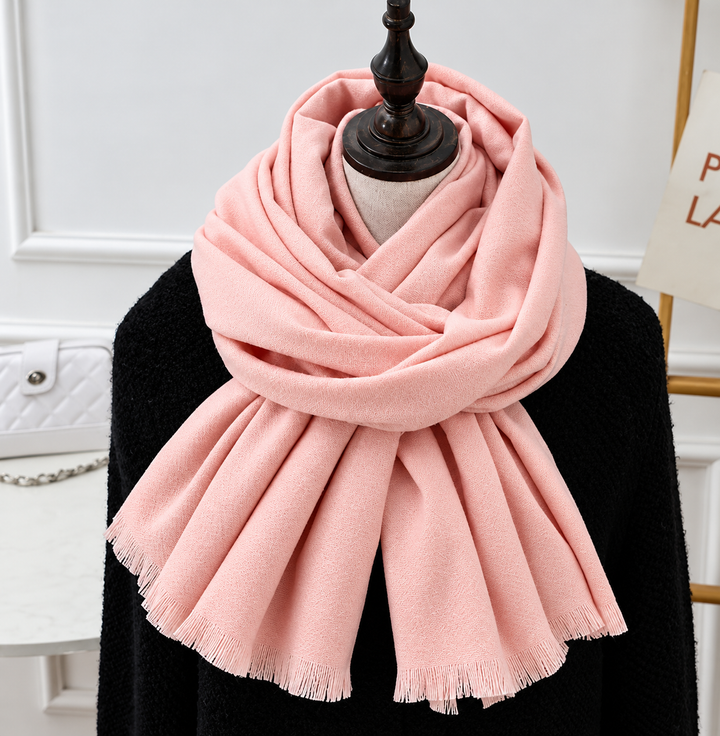 Écharpe rose pâle à franges, portée enroulée autour du cou d'un mannequin en noir 6