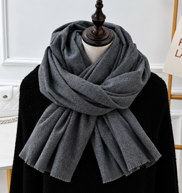 Écharpe gris anthracite à franges, drapée sur un mannequin habillé d'un pull noir 7