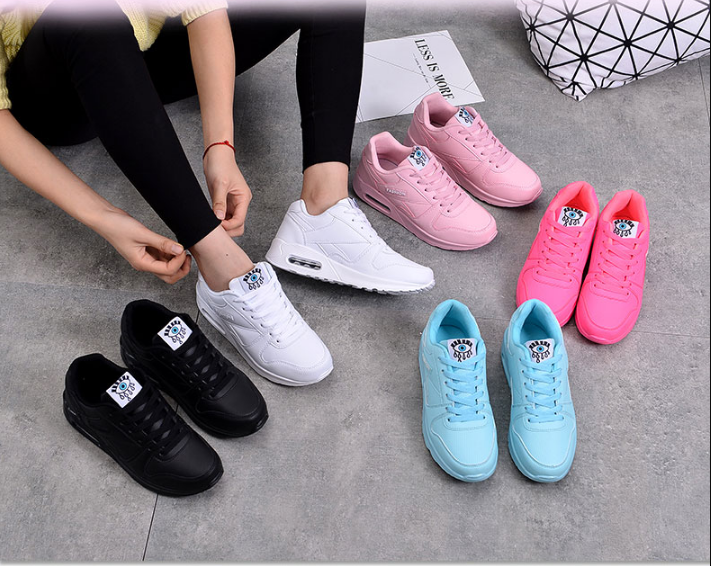 Paires de baskets noires, blanches, roses, rose vif et bleu clair posées au sol, une personne lace la blanche 4