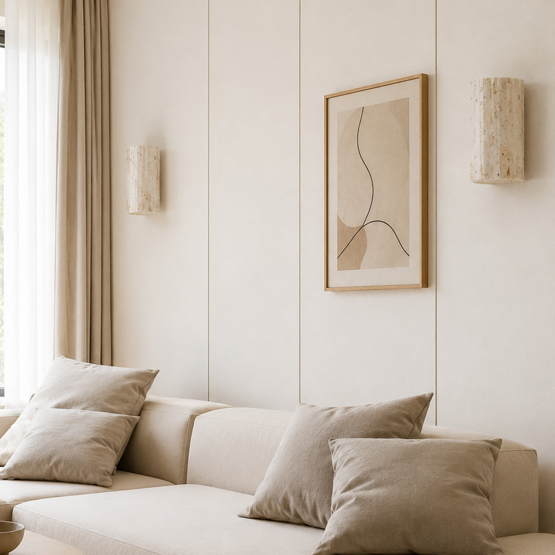 Deux appliques en pierre cannelée encadrent un tableau abstrait sur un mur clair, au-dessus d'un canapé beige et de coussins. 3