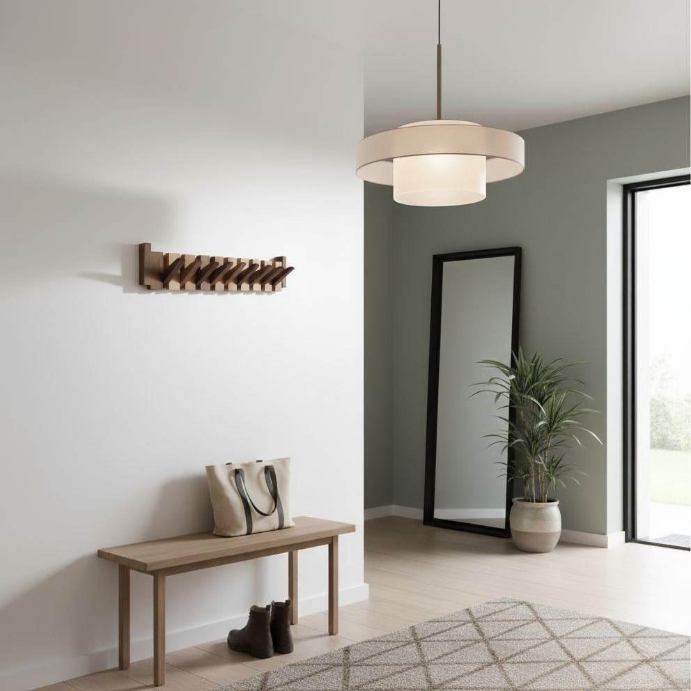 Porte-manteau en bois fixé au mur blanc d'une entrée, au-dessus d'un banc en bois avec un sac et des bottines. 1
