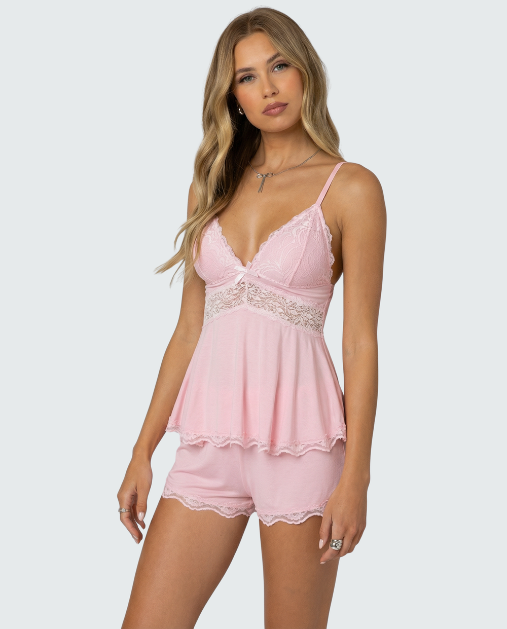Mannequin en trois-quarts portant l'ensemble rose, dentelle sur le buste et la taille, petit nœud au décolleté 2