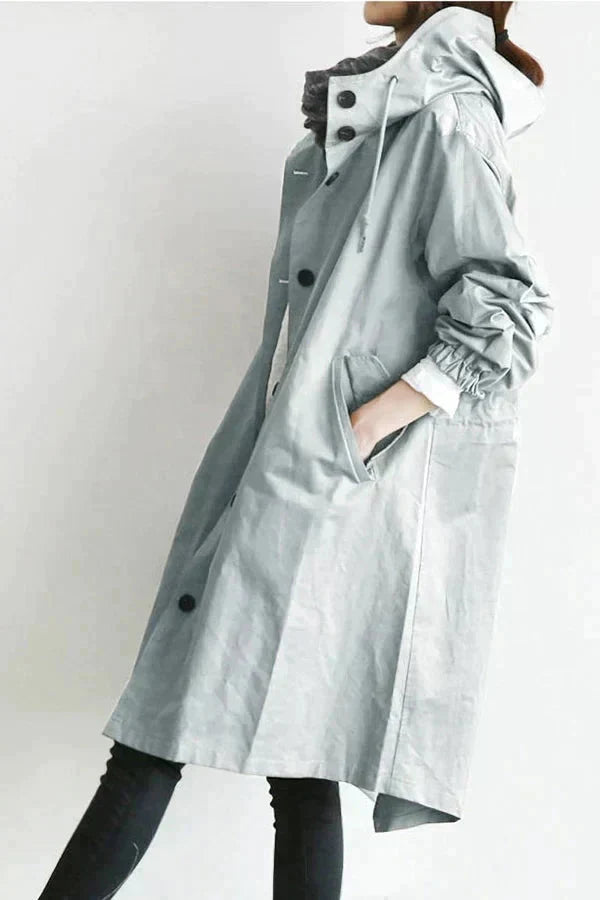 Trench gris clair vu de profil, avec cordon de capuche, poche latérale, poignet élastique et bas arrondi. 4