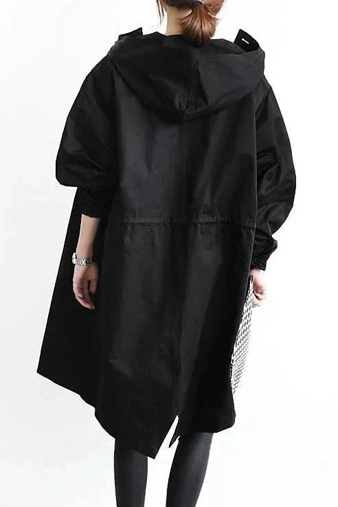 Trench noir vu de dos, avec capuche, cordon de serrage à la taille et bas fendu asymétrique. 7