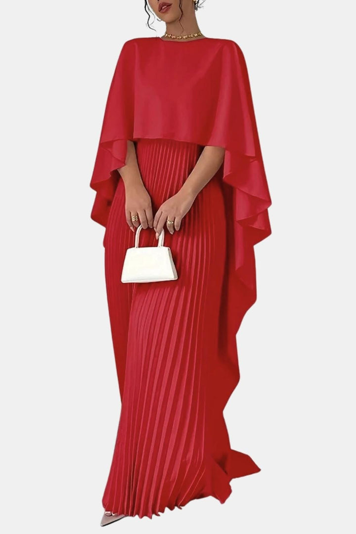 Robe rouge portée par une mannequin tenant un petit sac blanc, cape fluide et plis 8