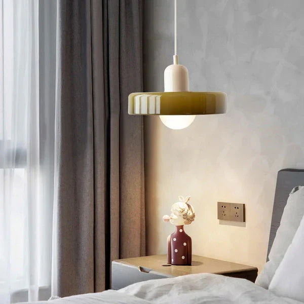 Suspension olive brillante à capuchon crème allumée au-dessus d'une table de chevet, dans une chambre aux rideaux gris. 20