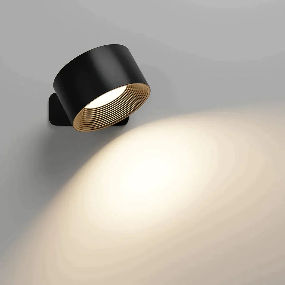 Version noire de l'applique, intérieur strié doré, allumée et orientée vers le bas avec un faisceau de lumière chaude. 2