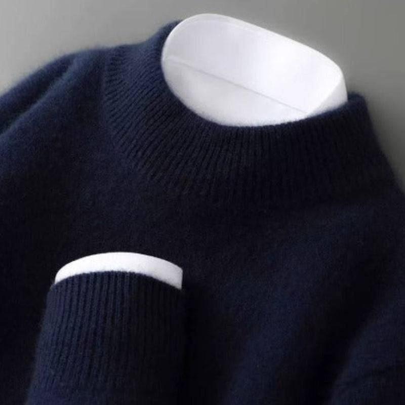 Pull bleu marine à col rond côtelé photographié de près, avec une chemise blanche visible à l'encolure et au poignet. 3