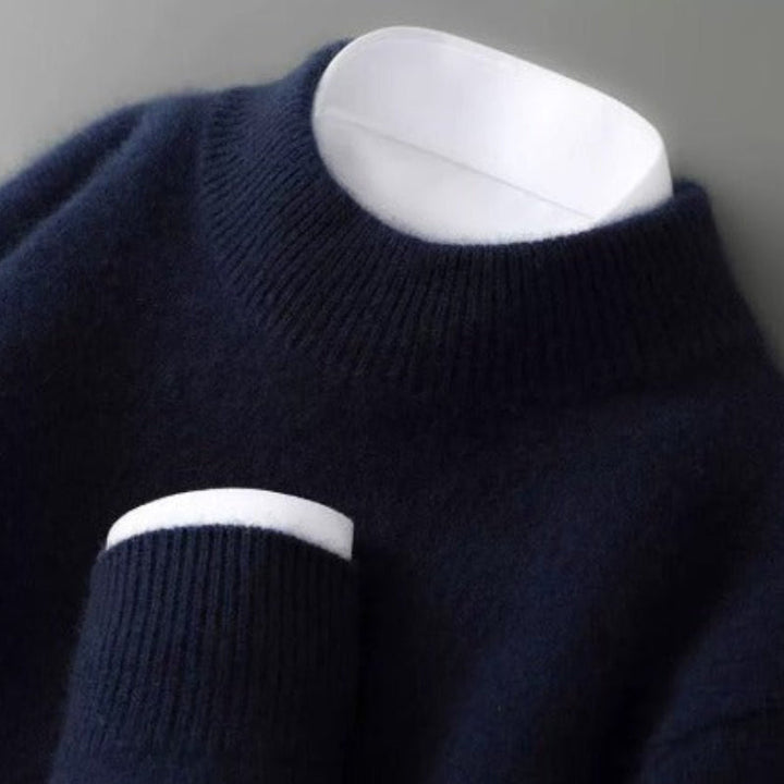 Pull bleu marine à col rond côtelé photographié de près, avec une chemise blanche visible à l'encolure et au poignet. 3