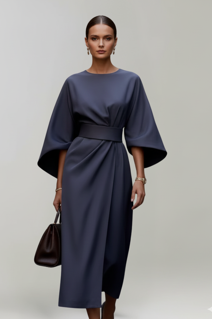Robe bleu marine portée de face par un mannequin tenant un sac à main brun 2