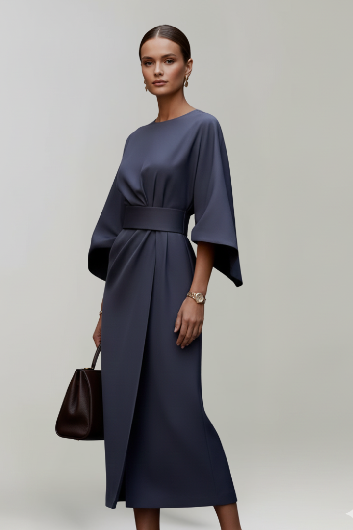 Robe bleu marine portée par un mannequin en trois quarts, portefeuille drapé sur la jupe 3