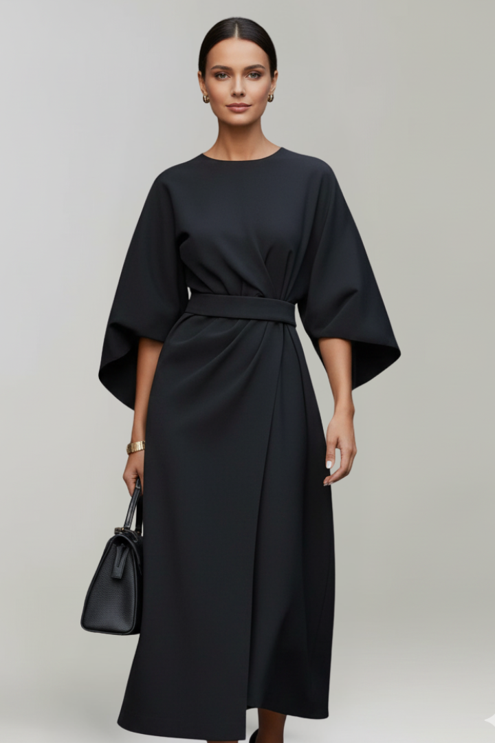 Robe noire portée de face par un mannequin avec sac noir, manches larges et ceinture 7