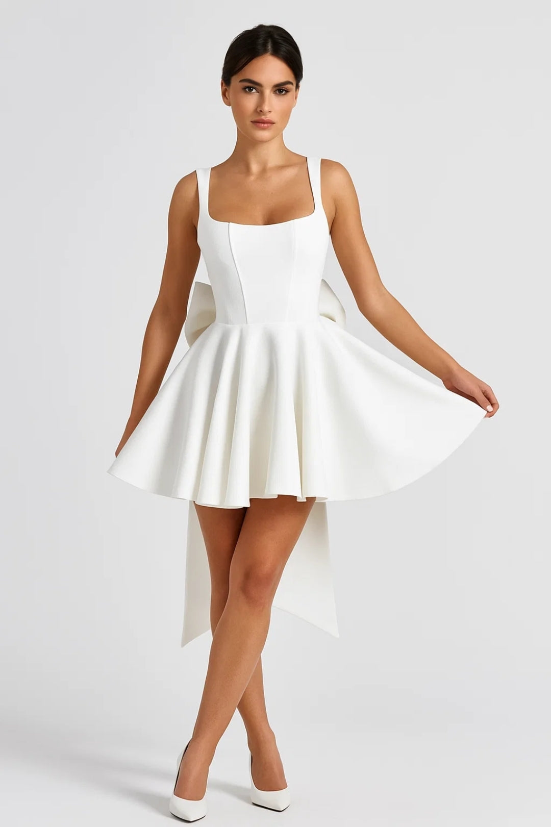 Mannequin portant la robe blanche de face, tenant sa jupe évasée, avec escarpins blancs 3