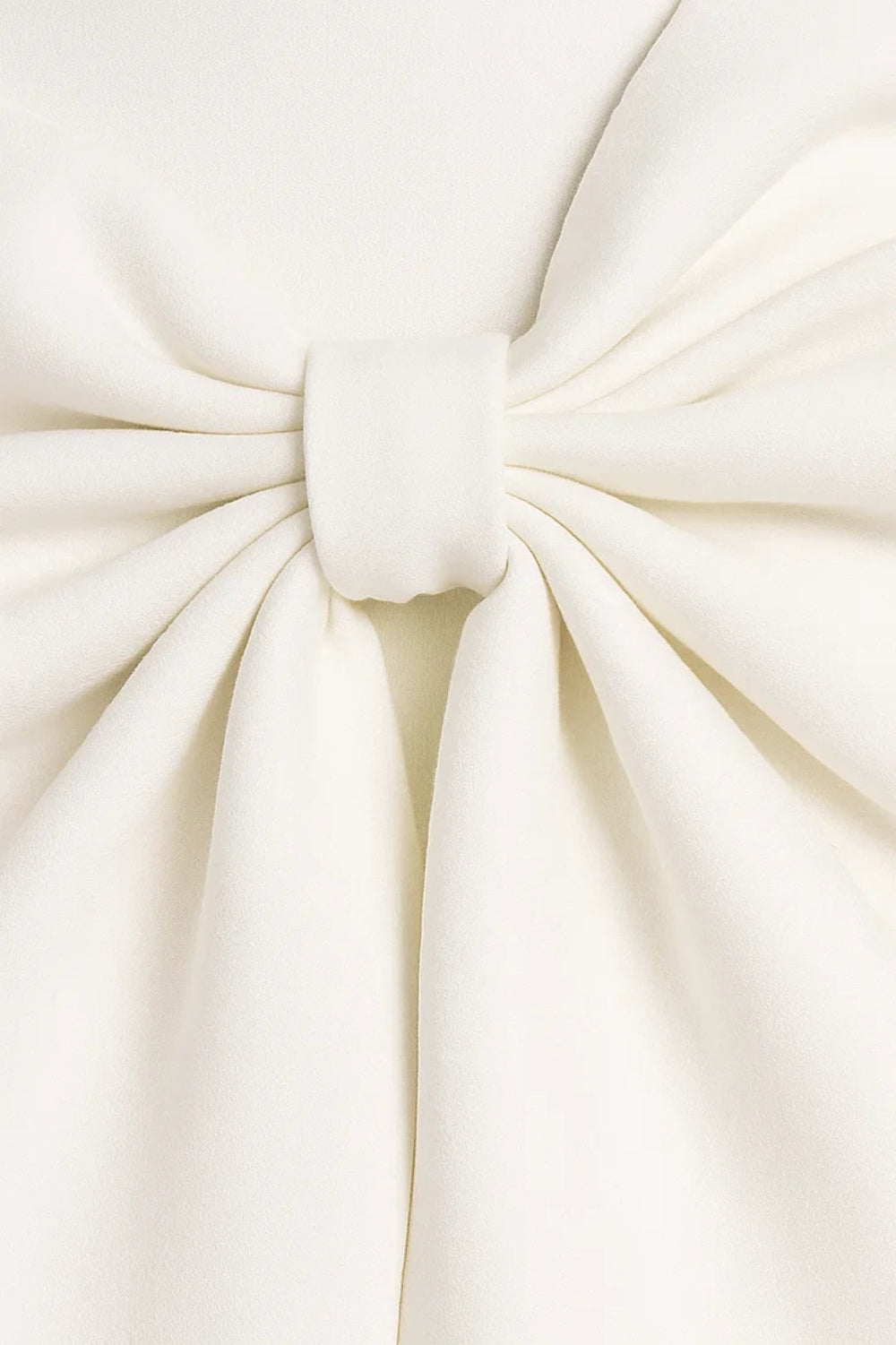 Gros plan sur le nœud plissé de la robe blanche, retenu par une petite bande de tissu 2