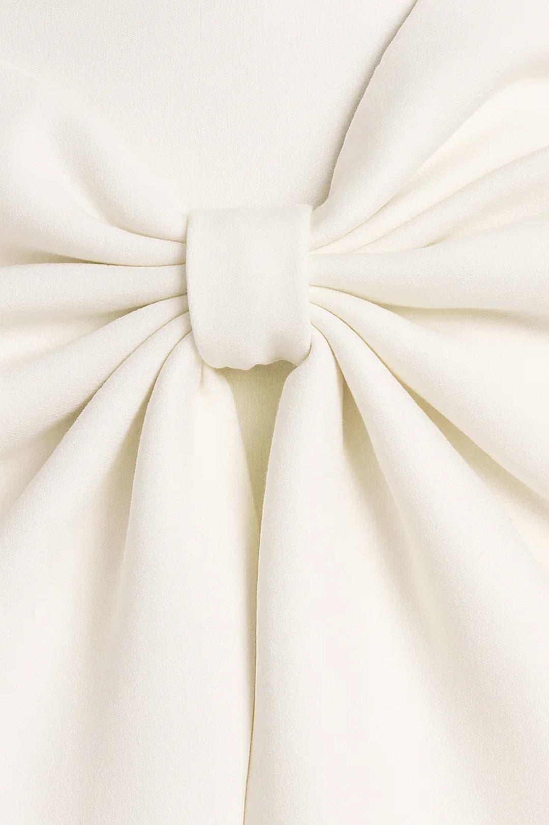 Gros plan sur le nœud plissé de la robe blanche, retenu par une petite bande de tissu 2