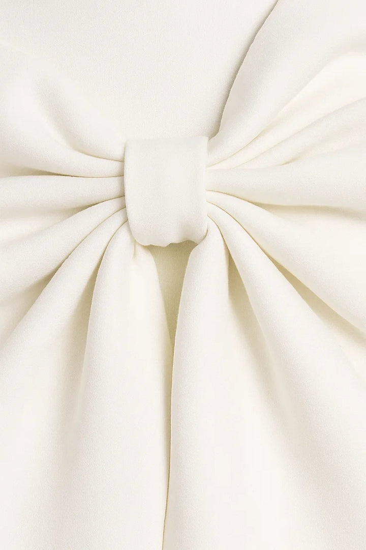 Gros plan sur le nœud plissé de la robe blanche, retenu par une petite bande de tissu 2