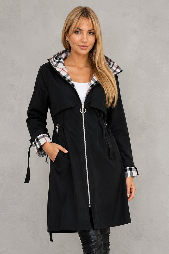 Femme portant l'imperméable noir fermé par un zip à anneau argenté, avec doublure à carreaux à la capuche et aux poignets. 3