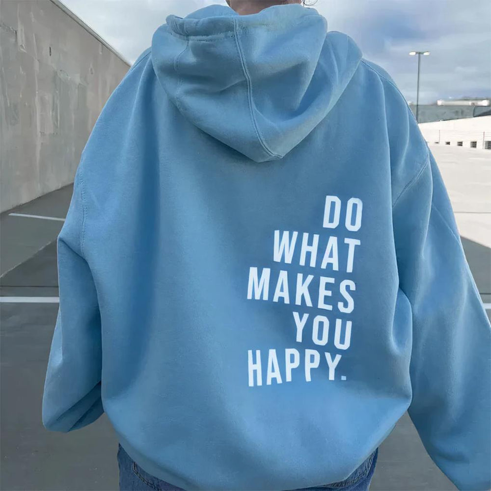 Vue de dos d'un sweat à capuche bleu ciel ample porté dehors, avec un grand message imprimé en blanc dans le bas du dos. 2